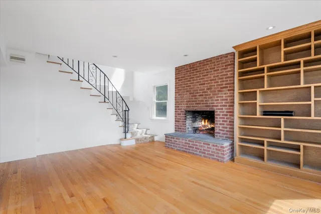 a view of empty room with wooden floor and fireplace