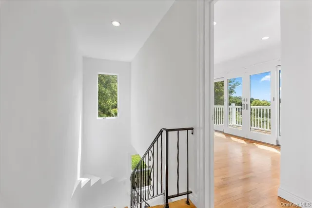 a view of a hallway with wooden floor and stairs