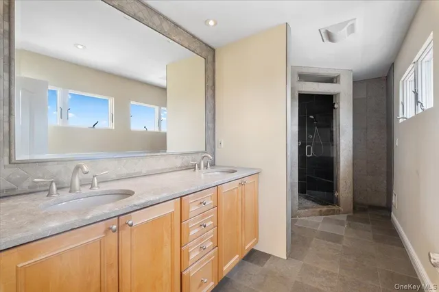 a bathroom with a granite countertop sink and a mirror