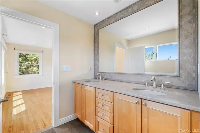 a bathroom with a granite countertop sink and a mirror