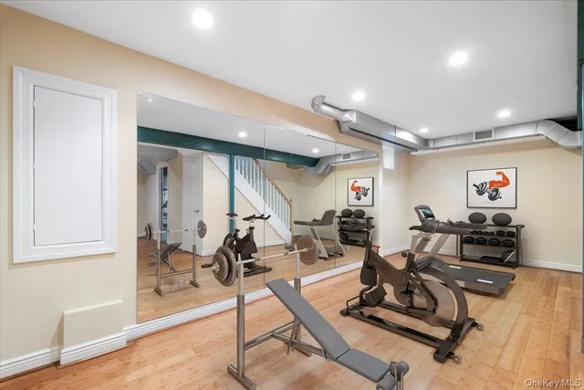 a living room with furniture a flat screen tv and gym equipment