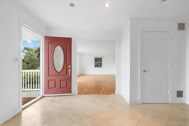 an empty room with entrance door and windows