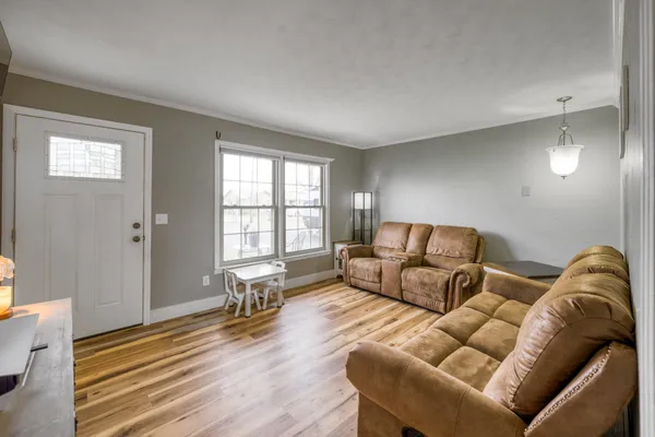 a living room with furniture and a wooden floor