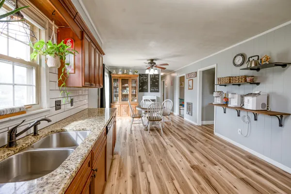 a view of a kitchen with kitchen island a counter top space a sink and cabinets