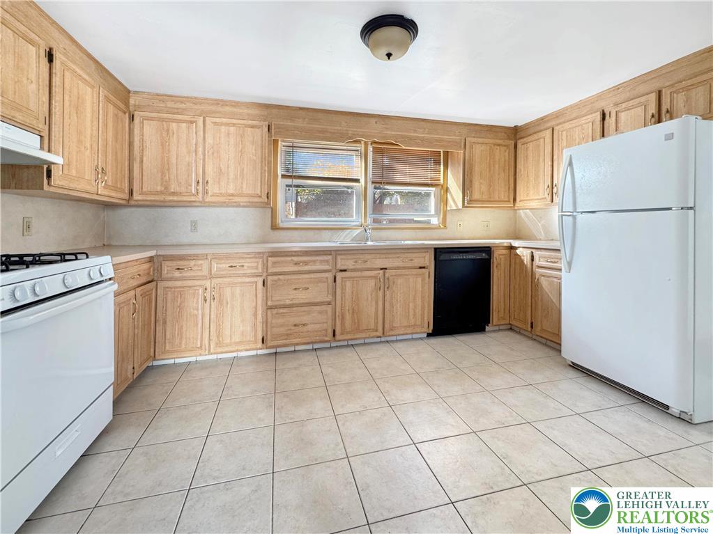 257 East 2nd Street Wind Gap, PA 18091 - Photo 6 of 14 a kitchen with stainless steel appliances granite countertop a refrigerator sink and cabinets