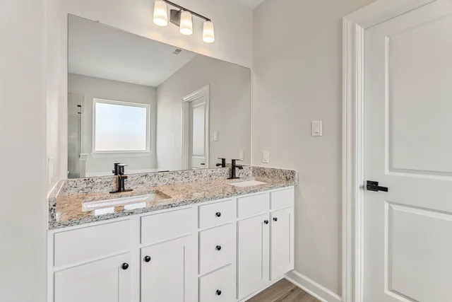 a kitchen with stainless steel appliances a refrigerator a sink dishwasher a stove and white cabinets with wooden floor