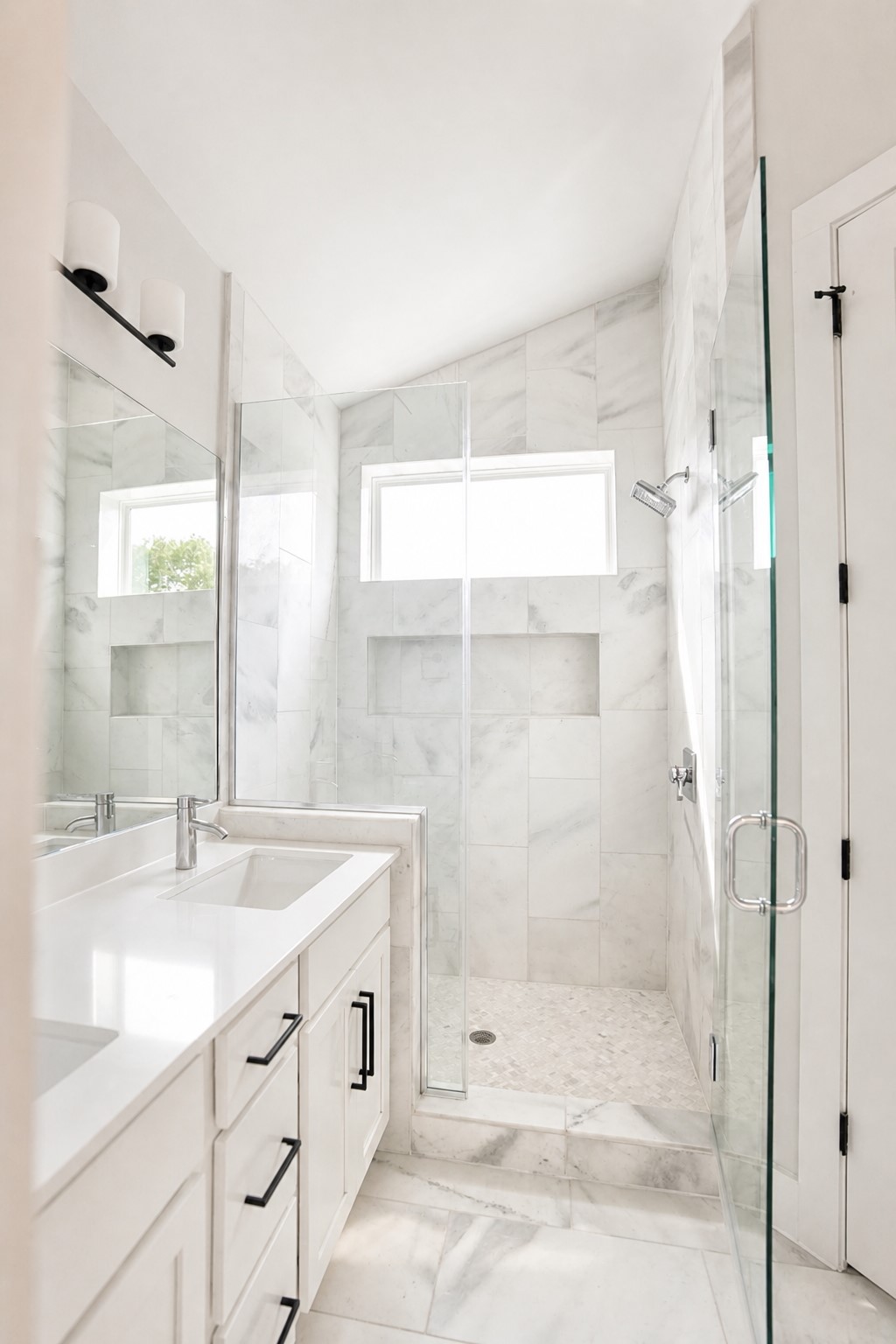 1123 Omega Avenue, Unit 1 Austin, TX 78721 - Photo 19 of 40 Contemporary bathroom featuring a dual vanity with white countertops, integrated sinks, and matte black hardware
