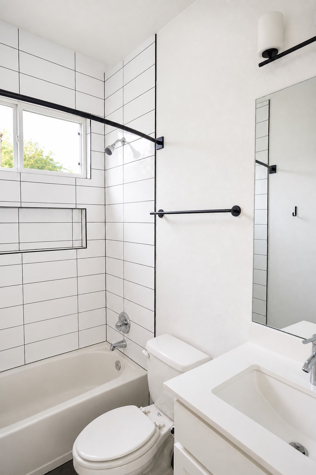 1123 Omega Avenue, Unit 1 Austin, TX 78721 - Photo 30 of 40 Bathroom featuring a white subway-tiled shower with black grout, built-in shower niche, white soaking tub, and a white vanity with an integrated sink