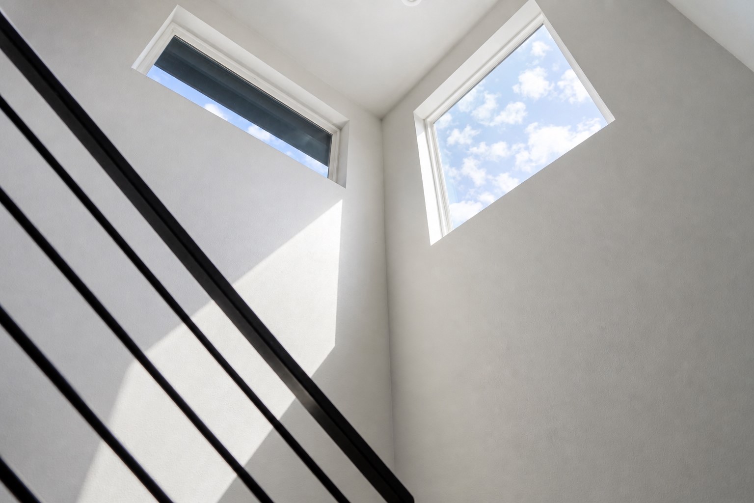 1123 Omega Avenue, Unit 1 Austin, TX 78721 - Photo 32 of 40 Modern staircase featuring horizontal black metal balusters and a white painted wall