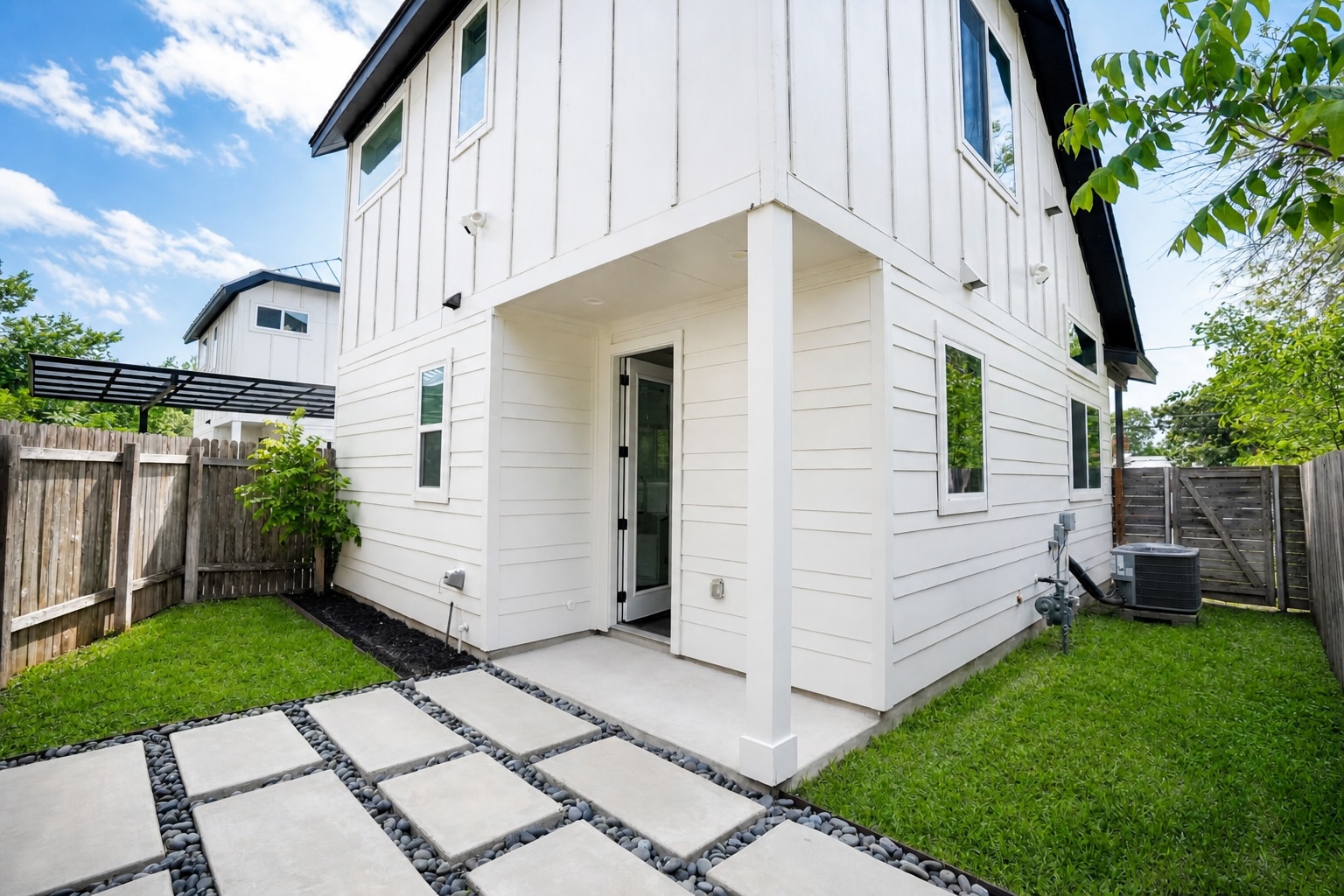1123 Omega Avenue, Unit 1 Austin, TX 78721 - Photo 6 of 40 Modern exterior featuring vertical and horizontal siding, a covered patio, and concrete paver pathway with dark pebble infill