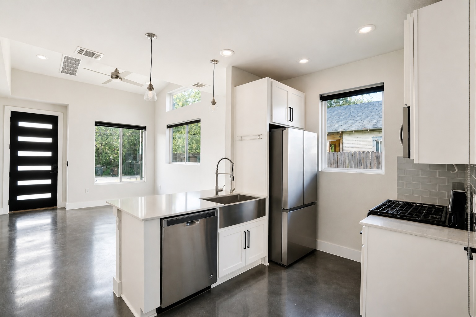1123 Omega Avenue, Unit 1 Austin, TX 78721 - Photo 7 of 40 Modern kitchen featuring white cabinetry, stainless steel appliances, and a central island with an integrated sink