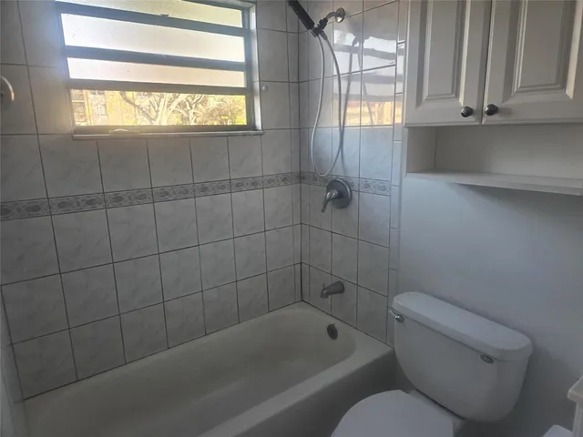a bathroom with a toilet bathtub and window