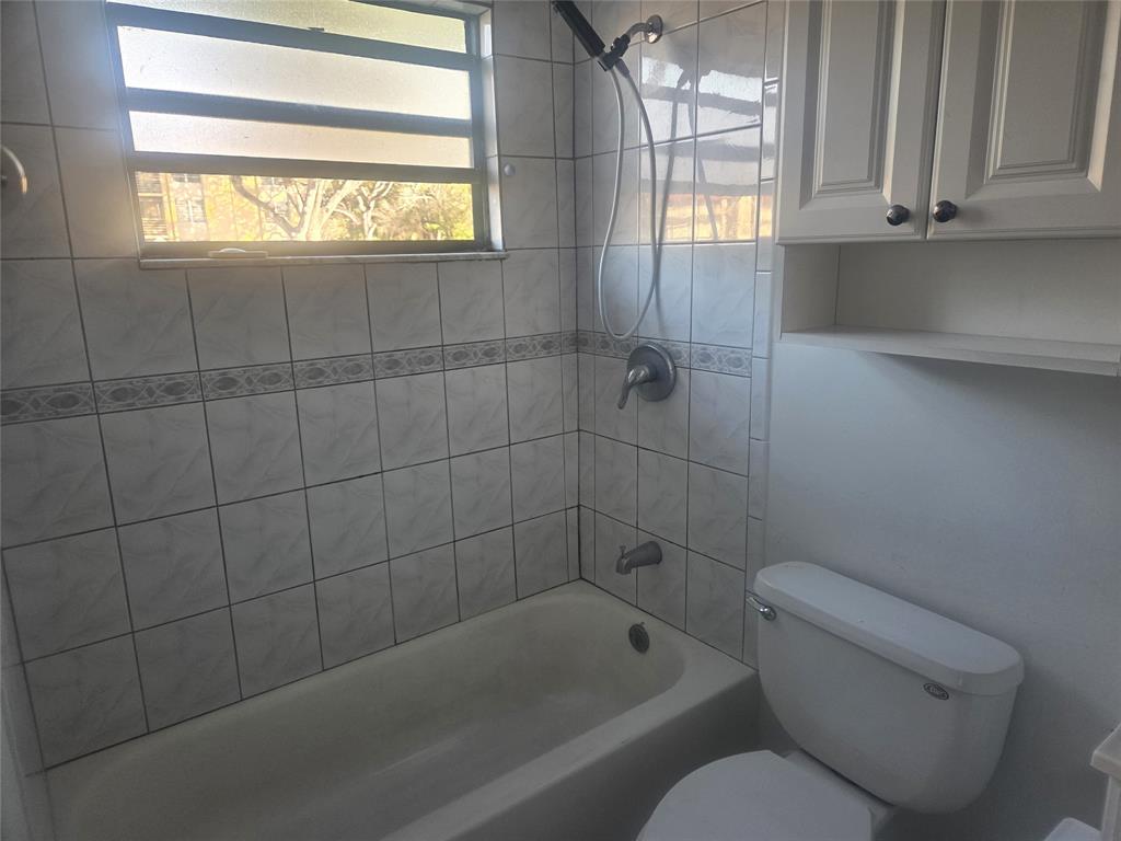 3252 Foxcroft Road, Unit 101 Miramar, FL 33025 - Photo 12 of 15 a bathroom with a toilet bathtub and window
