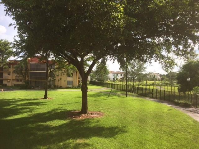 3252 Foxcroft Road, Unit 101 Miramar, FL 33025 - Photo 15 of 15 a view of a swimming pool with a yard
