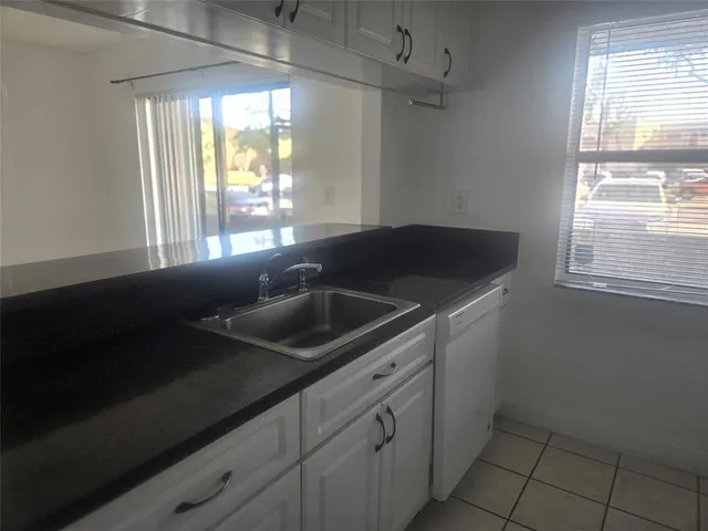 a kitchen with a sink cabinets and a window