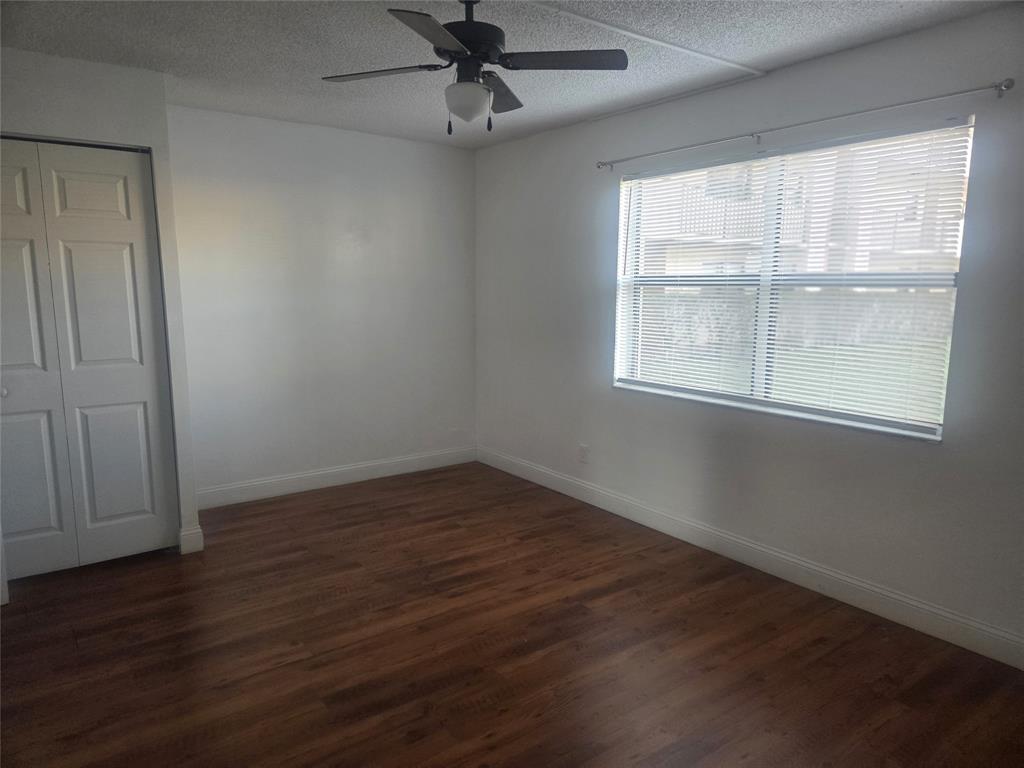 3252 Foxcroft Road, Unit 101 Miramar, FL 33025 - Photo 10 of 15 an empty room with wooden floor fan and windows