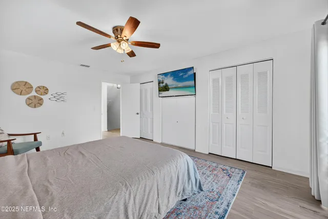 a bedroom with a large bed and a chandelier
