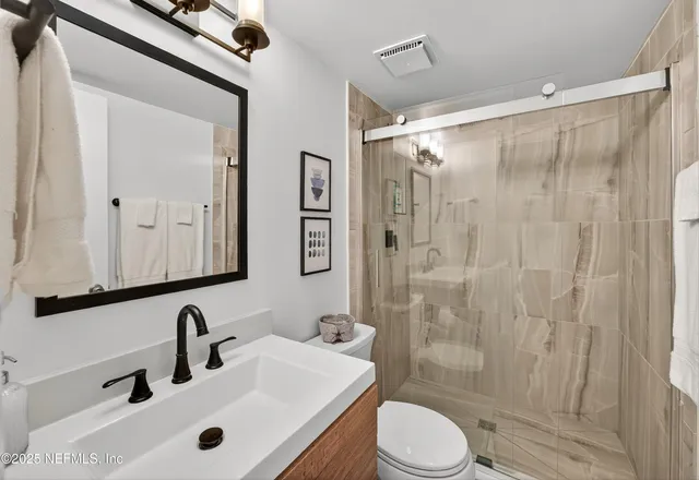 a bathroom with a sink a toilet and shower