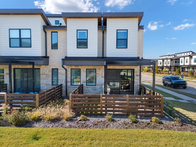 a front view of a house with lots of windows and outdoor seating