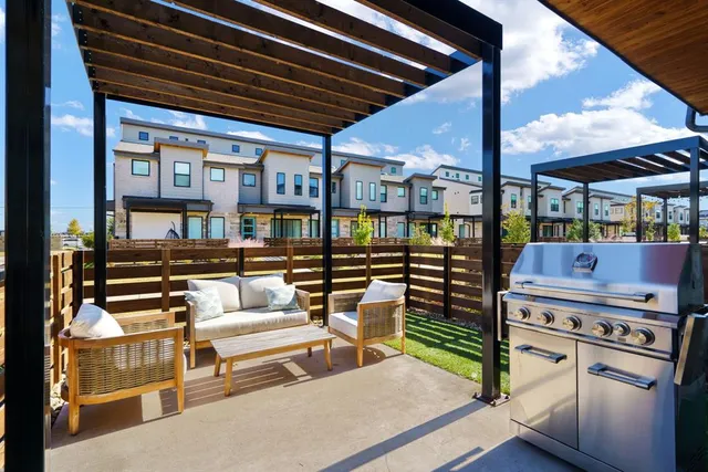 a roof deck with table and chairs and potted plants