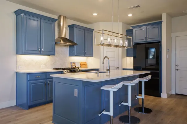 a kitchen with kitchen island granite countertop a sink and wooden cabinets