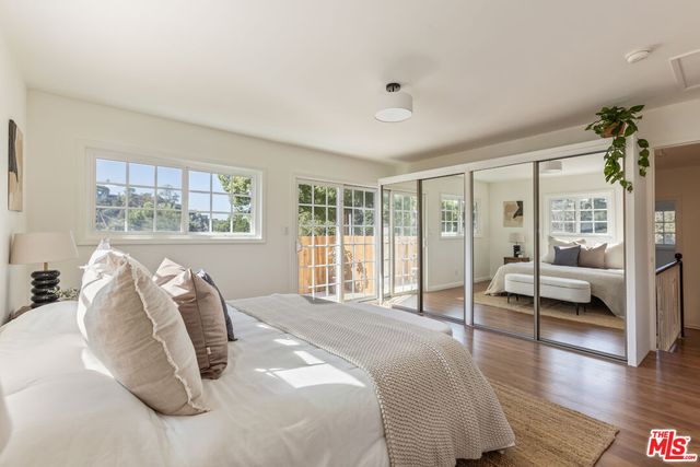 a bedroom with furniture and a large window