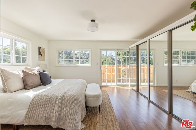 a bedroom with a large window and a balcony