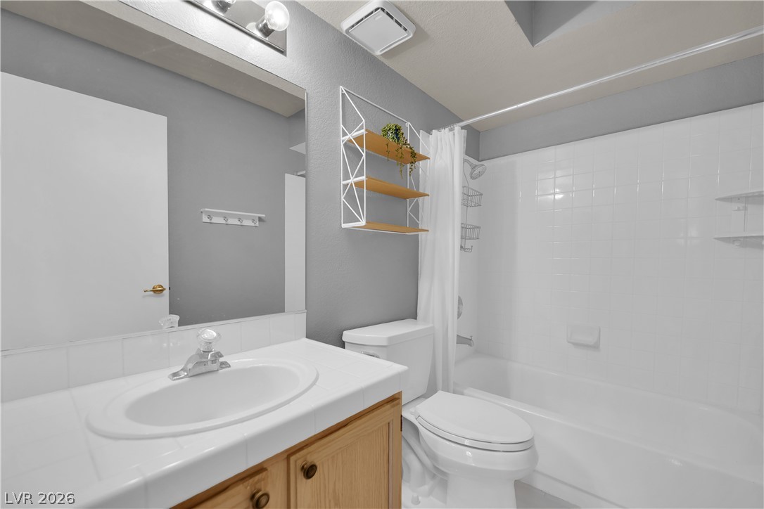 7570 West Flamingo Road, Unit 115 Las Vegas, NV 89147 - Photo 22 of 34 A well-appointed bathroom offers a clean vanity, full mirror, and a classic tub-shower combination.