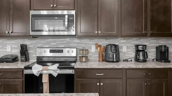 a kitchen with granite countertop a sink a stove and cabinets
