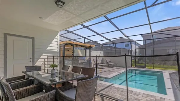 a view of a house with a swimming pool and sitting area