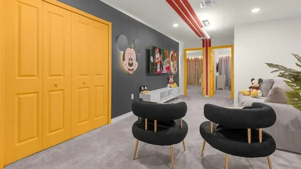 a living room with furniture and a painting on the wall