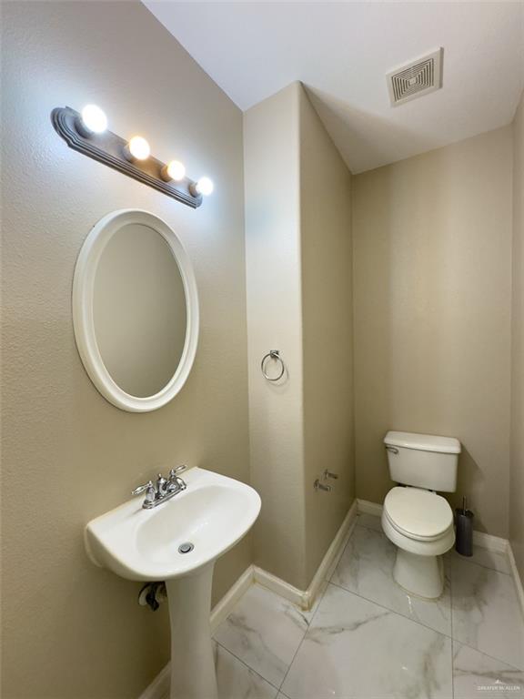 3402 San Sebastian Street Mission, TX 78572 - Photo 20 of 37 a bathroom with a toilet a sink and mirror