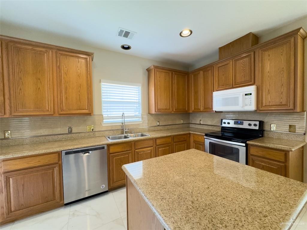 3402 San Sebastian Street Mission, TX 78572 - Photo 6 of 37 a kitchen with a sink stove top oven and cabinets