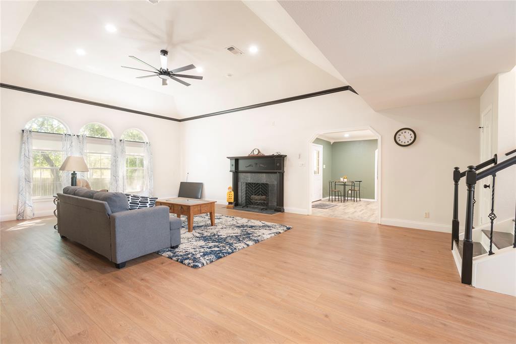 2020 Arbor Bend Road Bonham, TX 75418 - Photo 18 of 40 Living area with recessed lighting, a fireplace with flush hearth, a ceiling fan, light wood-style floors, and arched walkways