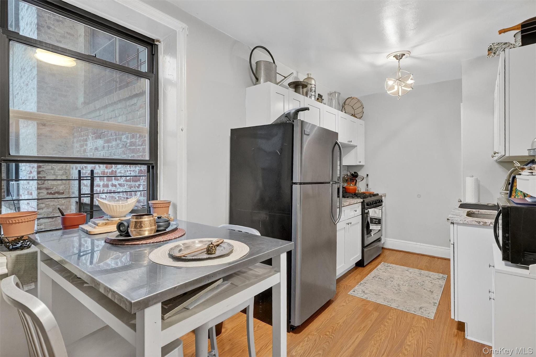 475 Bronx River Road, Unit 2D Yonkers, NY 10704 - Photo 12 of 27 Kitchen featuring plenty of natural light, light stone countertops, stainless steel appliances, and white cabinets