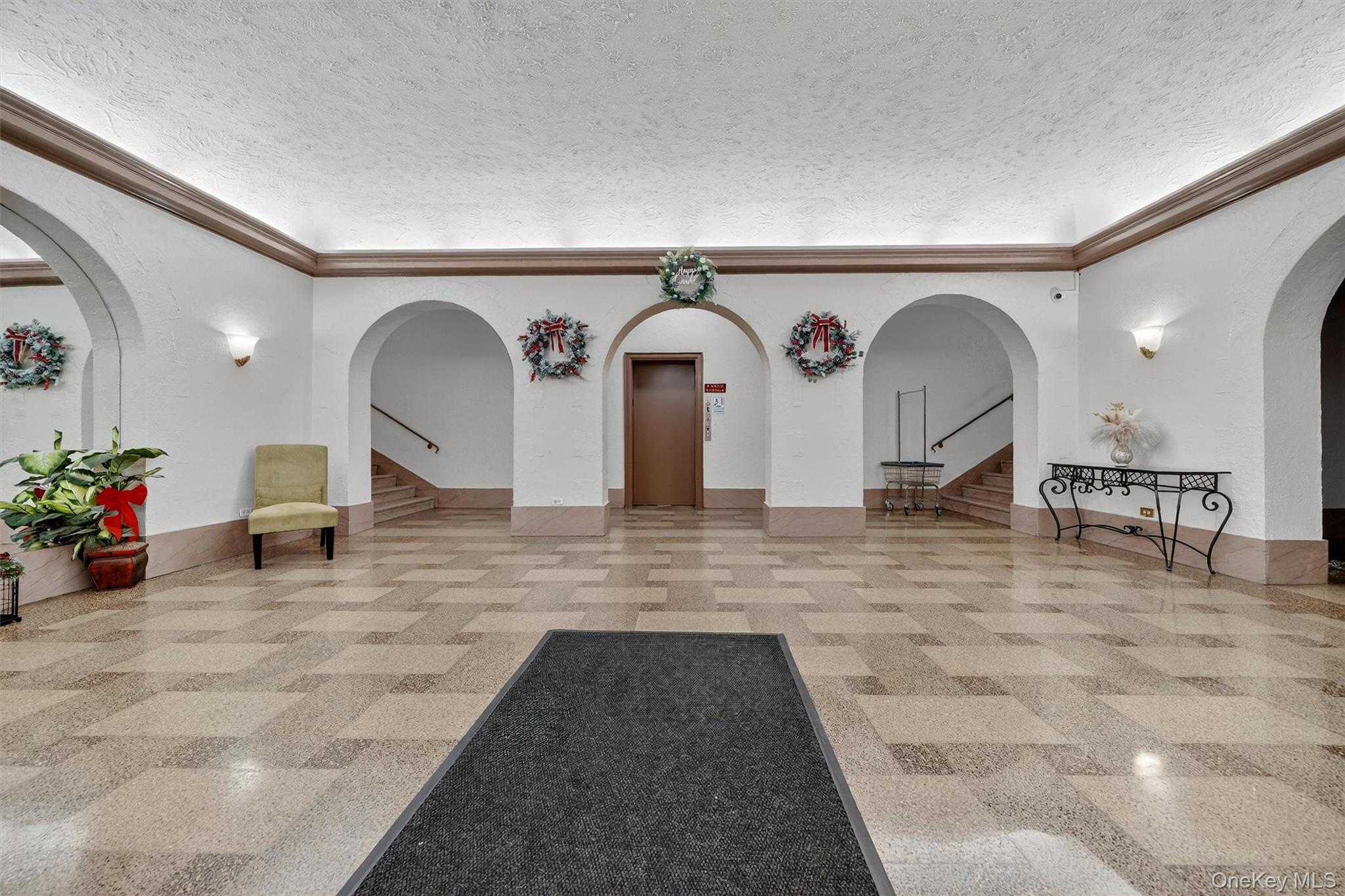 475 Bronx River Road, Unit 2D Yonkers, NY 10704 - Photo 4 of 27 Community lobby with stairway, a textured ceiling, and ornamental molding
