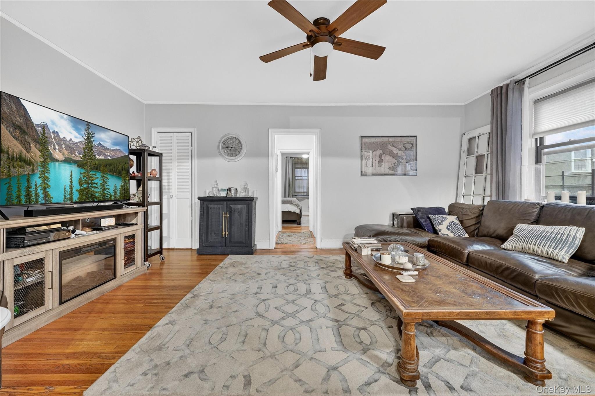 475 Bronx River Road, Unit 2D Yonkers, NY 10704 - Photo 6 of 27 Living area with light wood finished floors, a ceiling fan, and ornamental molding