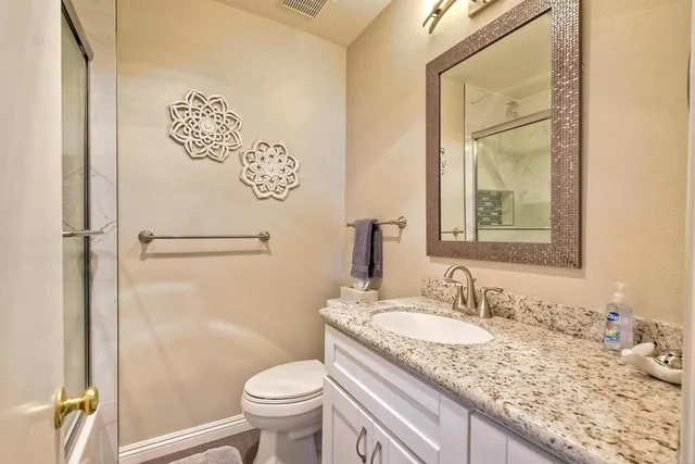 a bathroom with a granite countertop sink toilet and shower