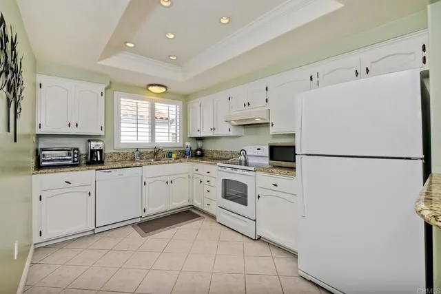 a kitchen with white cabinets and white appliances