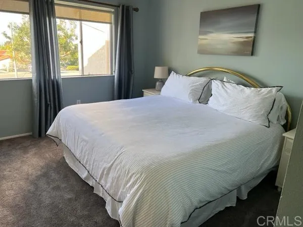 a bed sitting in a bedroom next to a window