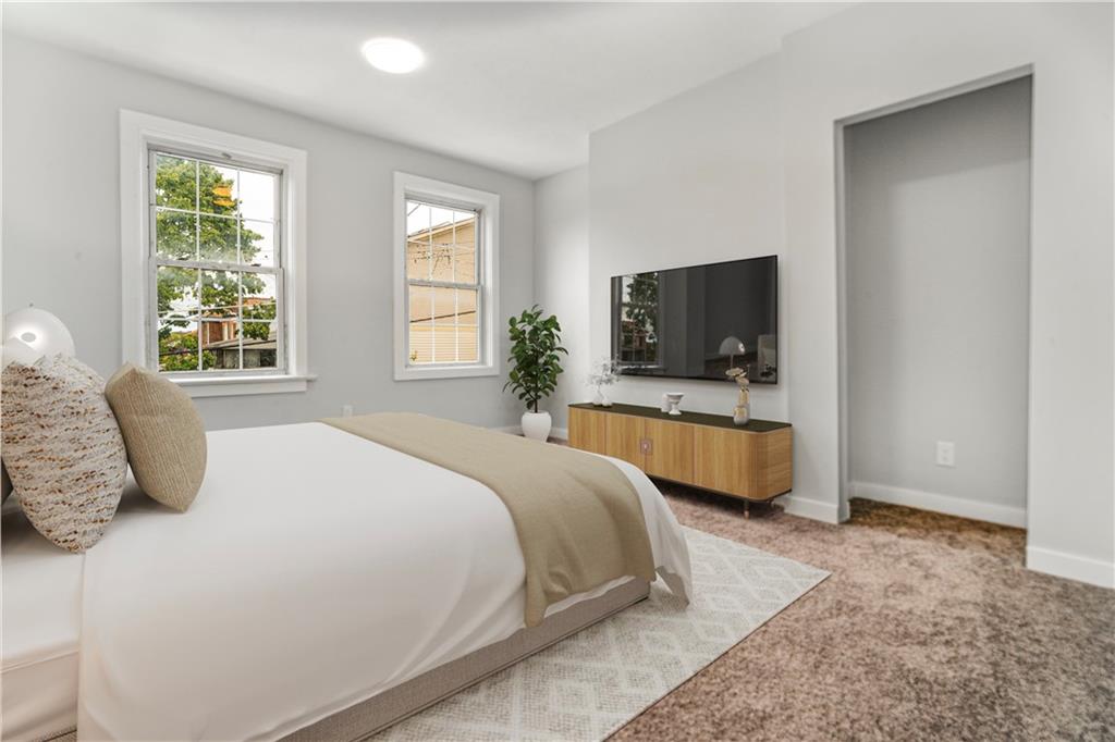 308 North Millvale Avenue Pittsburgh, PA 15224 - Photo 18 of 27 a bedroom with a large bed a flat tv screen and dresser