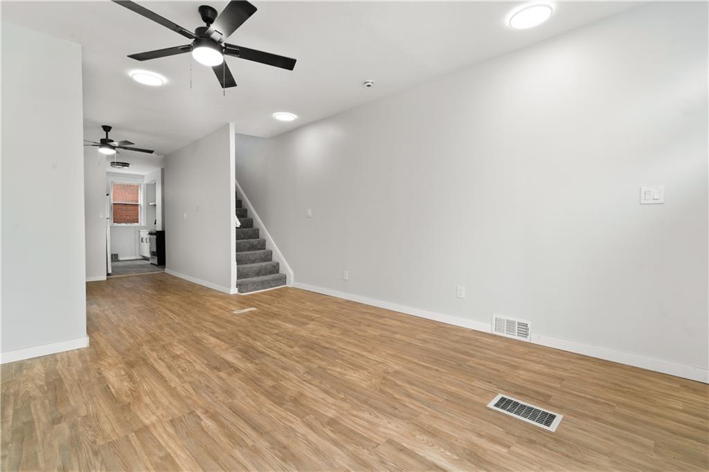308 North Millvale Avenue Pittsburgh, PA 15224 - Photo 6 of 27 an empty room with wooden floor ceiling fan and windows