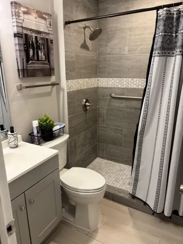 a bathroom with a sink a toilet and shower