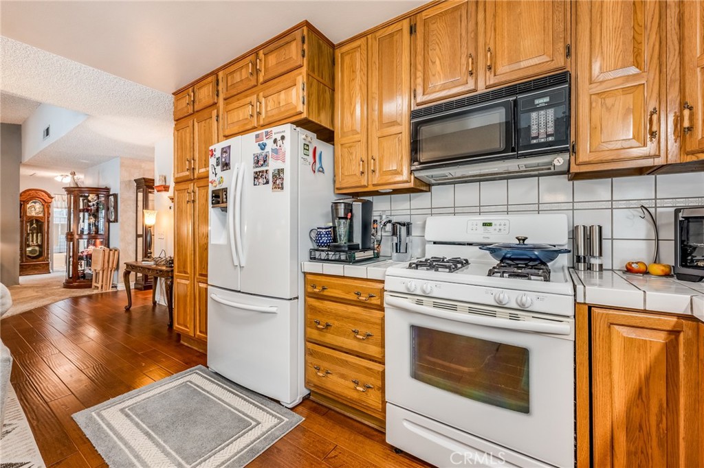2073 Suede Avenue Simi Valley, CA 93063 - Photo 11 of 33 a kitchen with stainless steel appliances granite countertop a refrigerator a stove a sink and a microwave