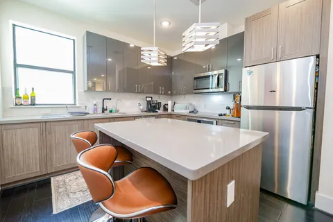 a kitchen with stainless steel appliances granite countertop a sink a refrigerator and a stove