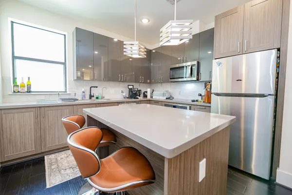 a kitchen with stainless steel appliances granite countertop a sink a refrigerator and a stove