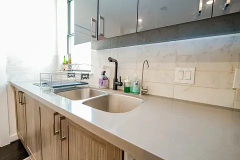 a kitchen with granite countertop a sink a stove and cabinets