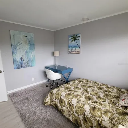 a bedroom with a bed and a lamp on dresser