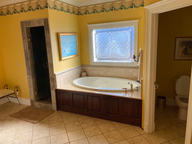 a bathroom with a tub sink and mirror