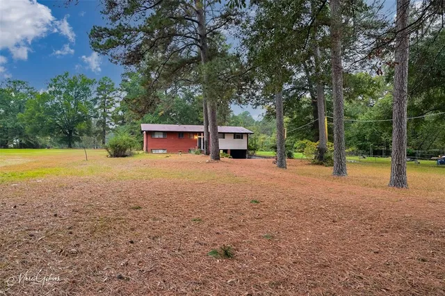 a view of a house with backyard and a tree